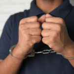 man in black shirt with handcuff .